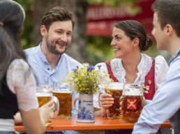menschen im sixengarten sitzen am tische und trinken eine maß bier