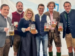 lächelnde menschen mit maßkrügen in der hand