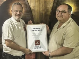 Fürst Wallerstein Vertriebsleiter Harald Schmidt überreicht Dragan Jonovic vom Gasthaus Zum Hubele in Nördlingen eine Ehrenurkunde für 40 Jahre Partnerschaft.